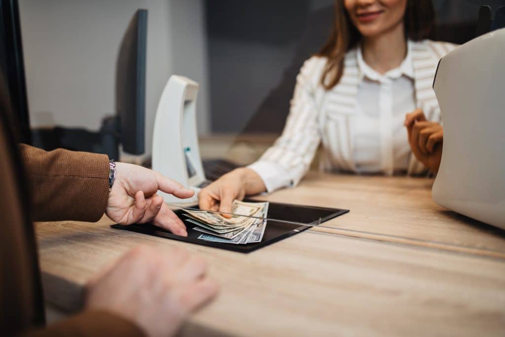 Customer receiving cash from a teller at a local branch, representing community banking in North Louisiana with GBT.
